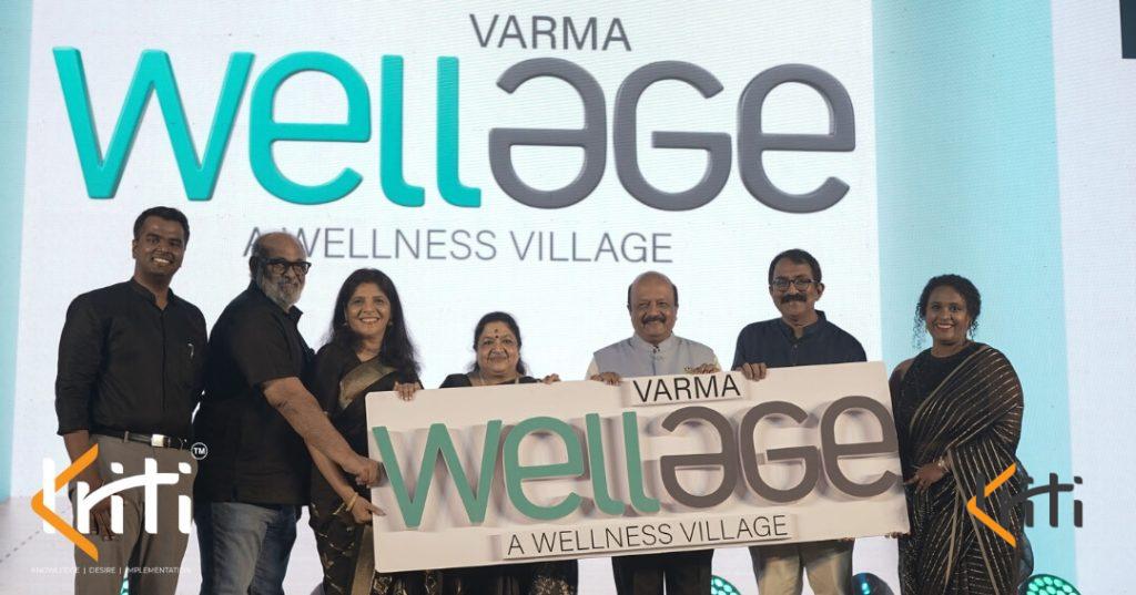 Team holding a branded event backdrop banner for Varma Wellage wellness village by Kriti Events