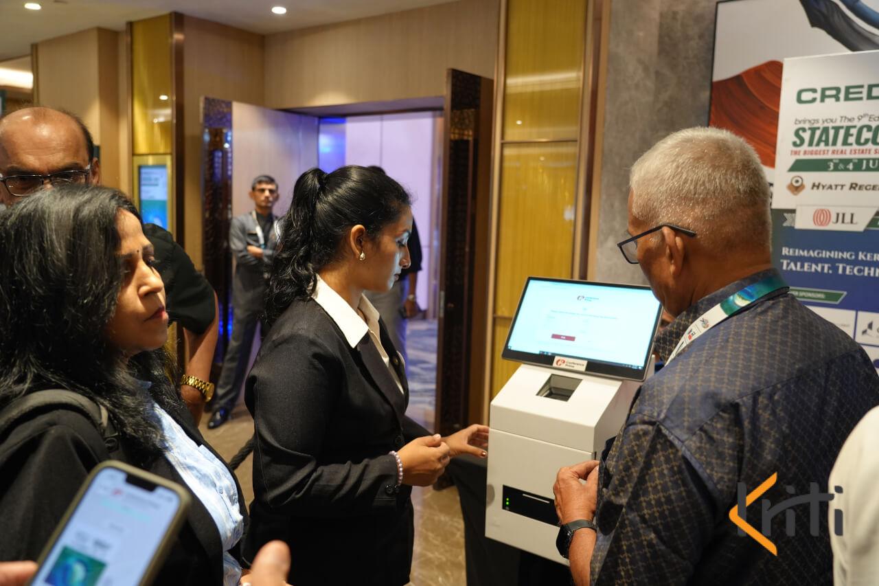 Attendees checking in at an automated digital registration kiosk during a corporate event by Kriti Events